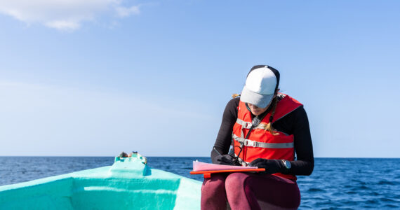 an oceanographer taking notes on a boat