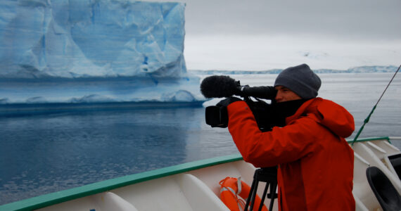 a person filming an ocean documentary in the arctic