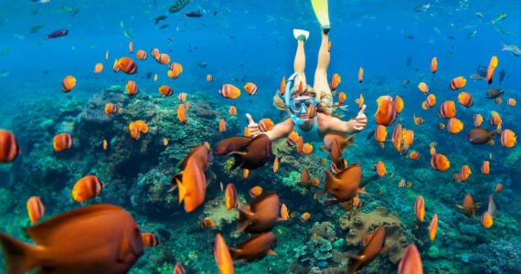 a woman snorkeling in crystal clear water