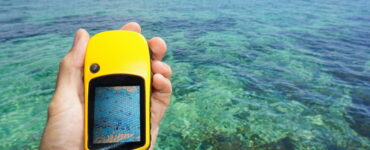 person holding a gps out over the water