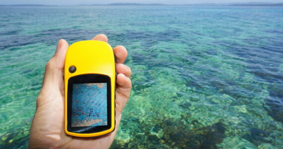 person holding a gps out over the water