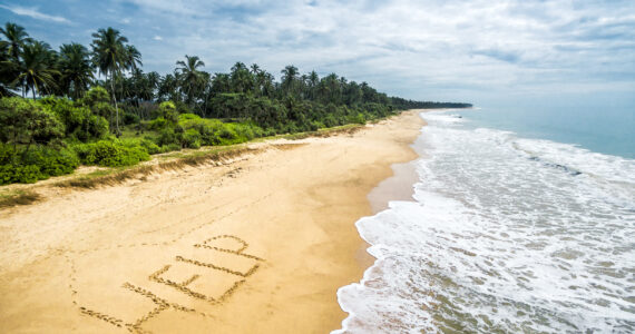 the word help written in the sand of a deserted island