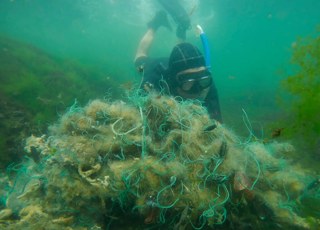 a diver picking up ghost gear from the water