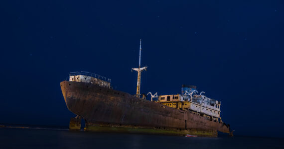a ghost ship floating in the sea at night