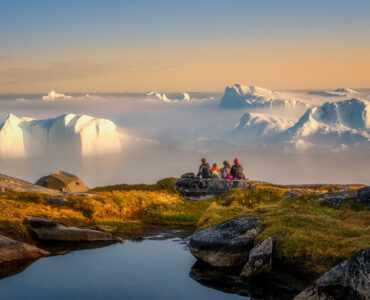 people staring out at a fjord in greenland