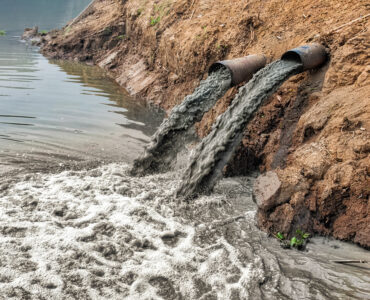 pipes spewing toxic waste into water
