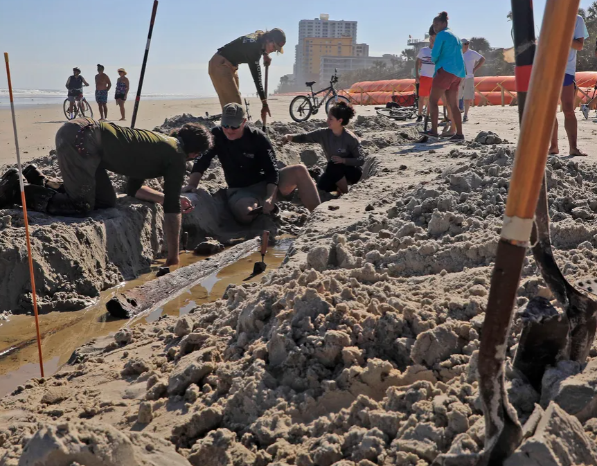 archaeologists digging up a shipwreck on daytona shores beach