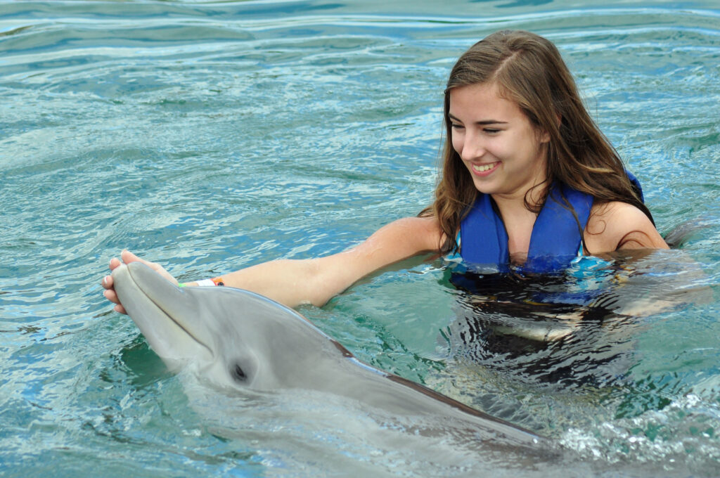 woman in the ocean with a dolphin