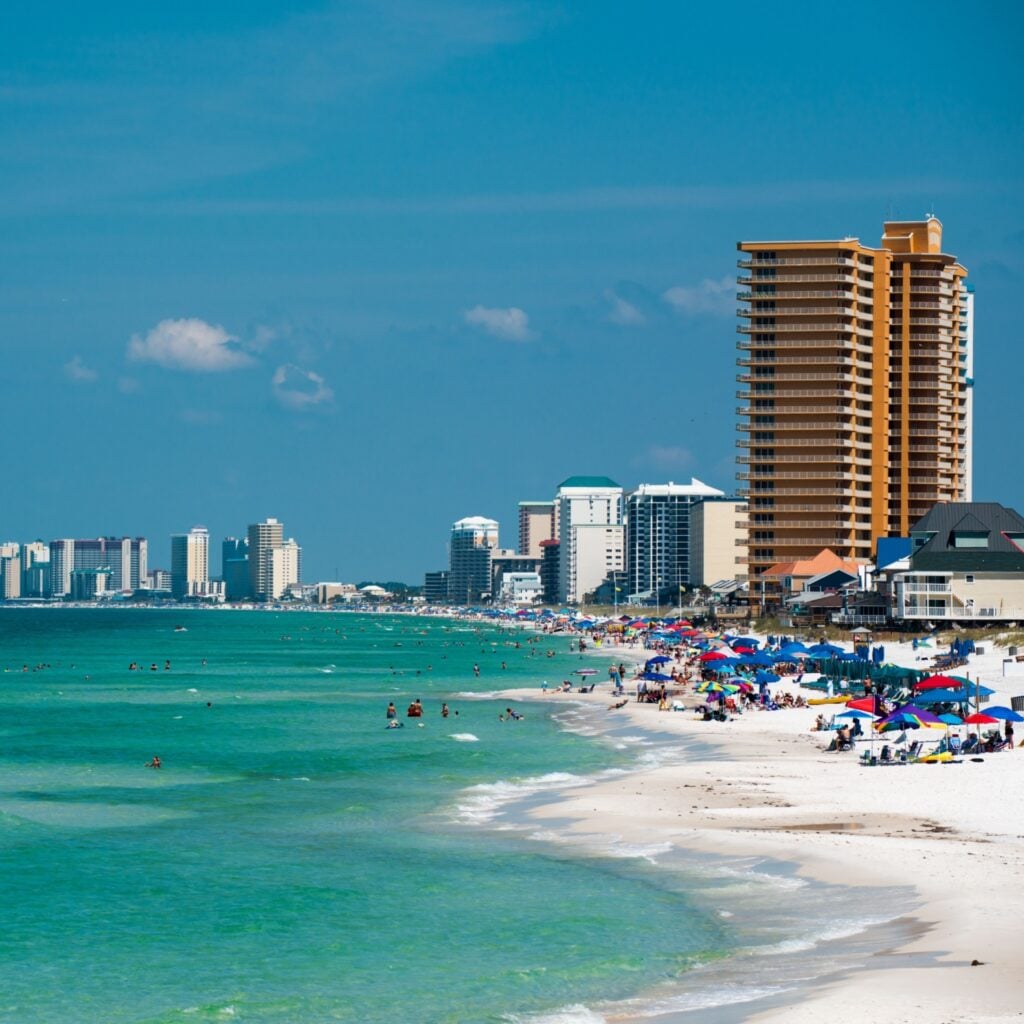 Panama City Beach features sugar-white sand, clear turquoise water, high-rise resorts, and a lively crowd enjoying the sun along Florida’s Emerald Coast.
