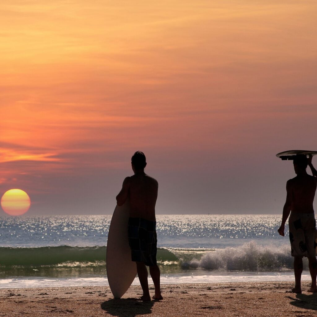 two surfers waiting for the wave in Cocoa Beach, Florida, usa, at sunset