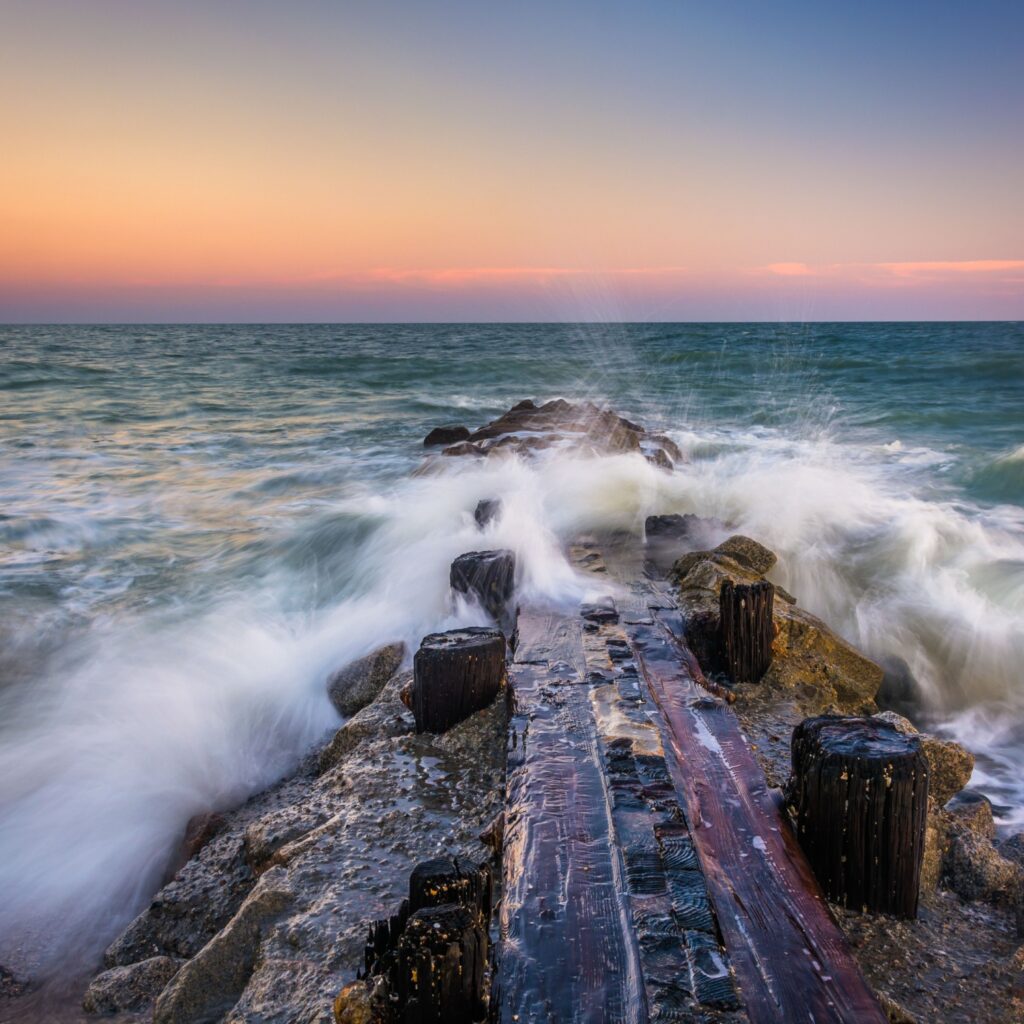 Waves and a jetty at sunset in the Atlantic Ocean at Edisto Beach, South Carolina