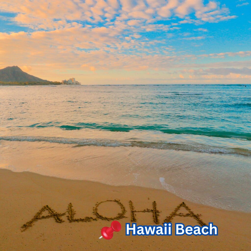 Golden sand with “ALOHA” written on it meets calm ocean waves under a colorful sky at Hawaii Beach, with mountains and cityscape in the distant background.