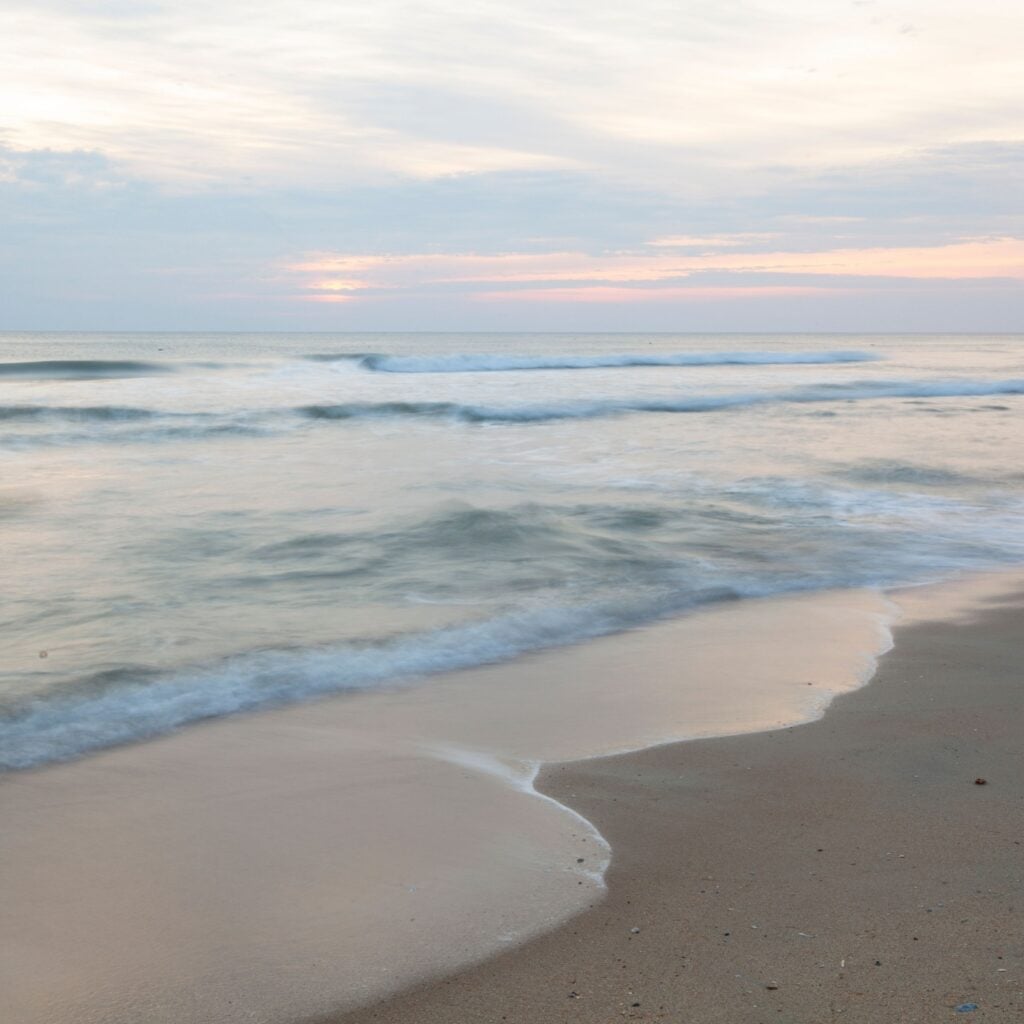 A scenic sunrise view of a beach on the Outer Banks in Nags Head, North Carolina.
