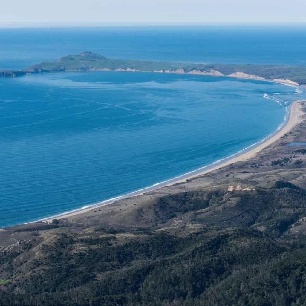 Aerial view facing northwest. Limantour Beach in foreground with Drakes Bay. Point Reyes National Seashore with clear skies.