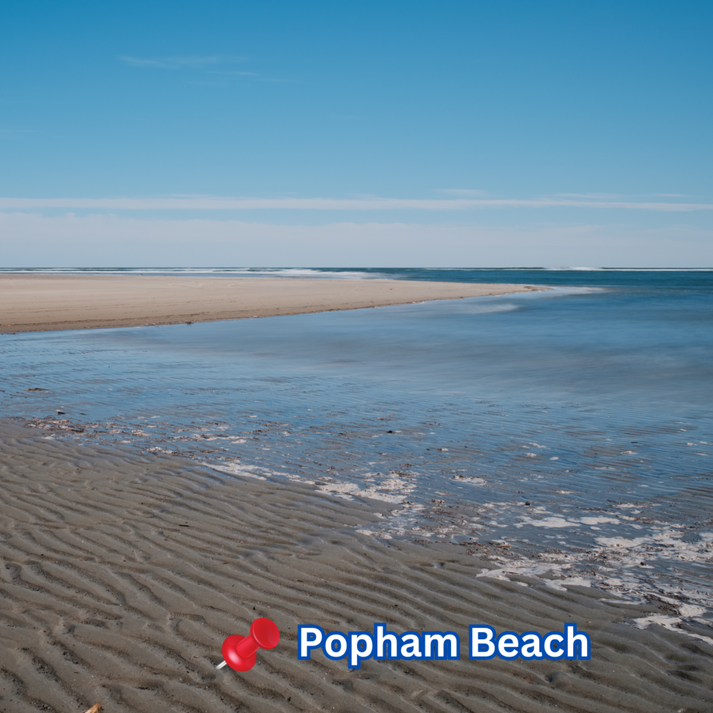 Low tide at Popham Beach in Phippsburg, ME, reveals rippled sand and shallow water under a clear blue sky, with gentle waves breaking in the distance.